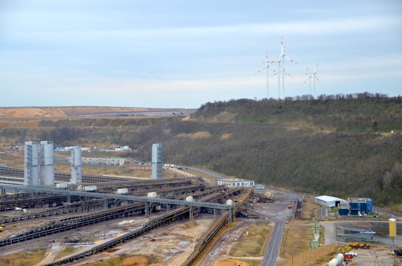 (c) J.P. van Soest. De overgang van het oude energiesysteem naar een nieuw is zichtbaar bij de bruinkoolmijn bij Garzweiler, Duitsland, die omringd wordt door windturbines.